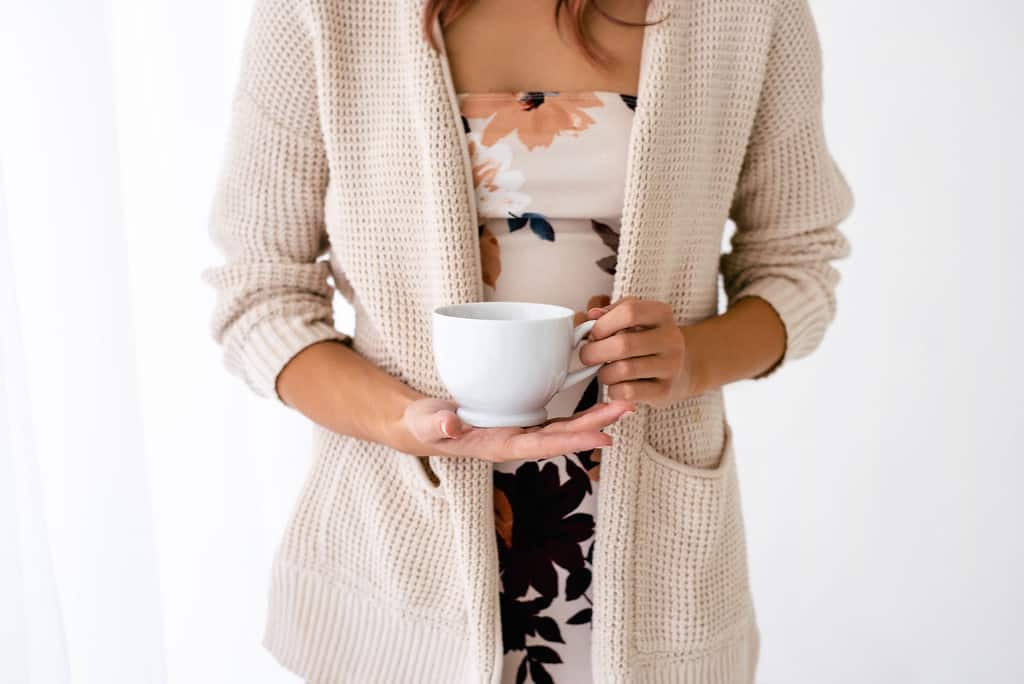 woman holding a coffee cup and thankful for an abundant life in Christ