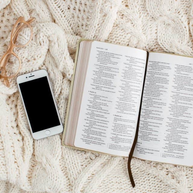 open Bible and phone on a blanket