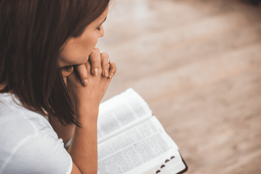 woman in morning prayer time resting on her Bible